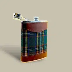 Stainless steel flask wrapped in green plaid fabric with brown leather trim, offering a classic look and comfortable grip.